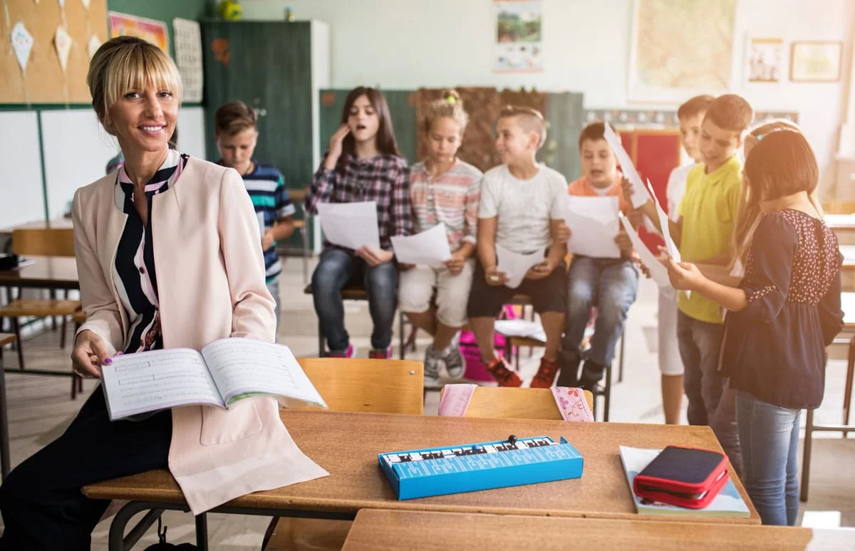 PrimaryMusicLessonPlansImage Teacher using elementary and primary music lesson plans with students in classroom